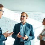 Engaged outsourced marketing director guiding a team in a modern office.